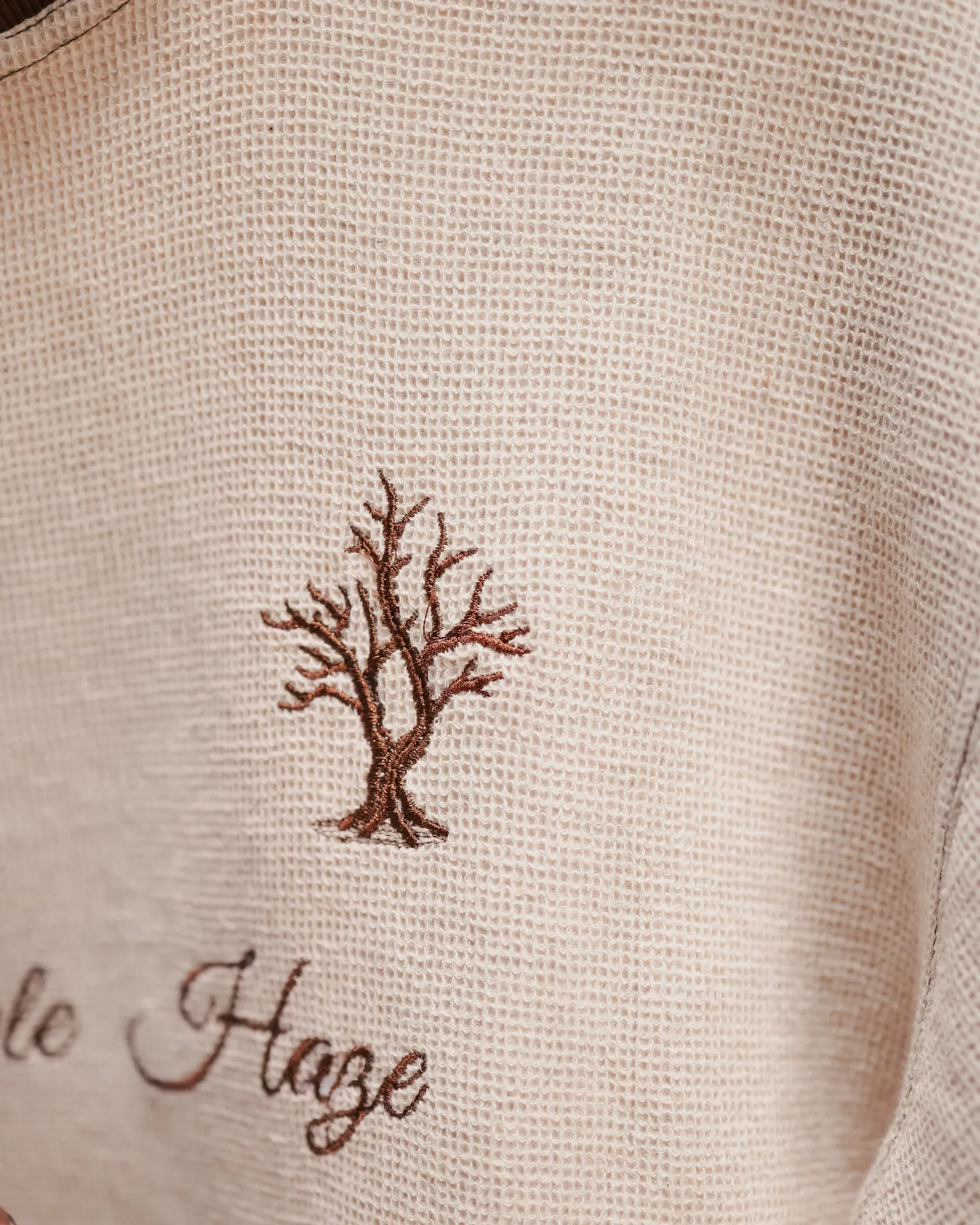 The open knit of the Pineapple Haze tee, close, under its embroidered tree